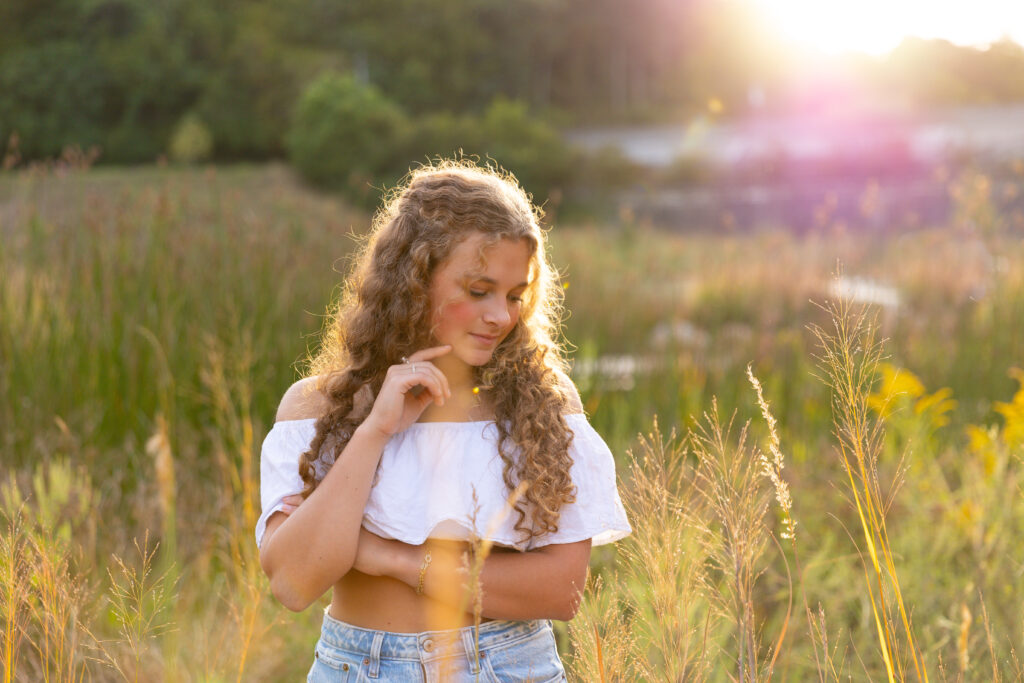 high School senior girl posing in front of golden tall grass in Eden Park