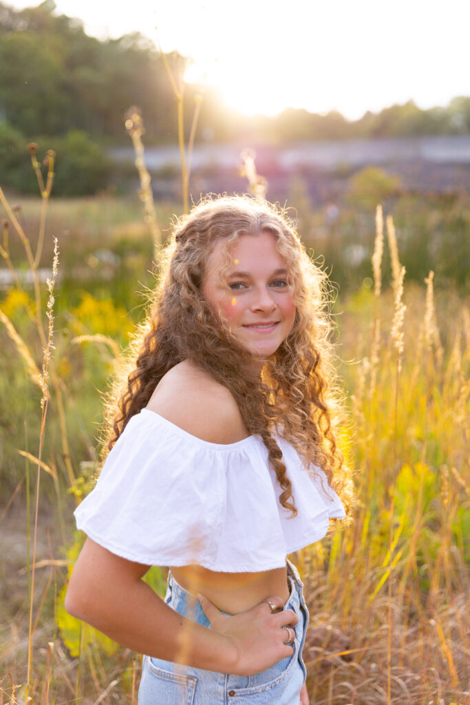 high School senior girl posing in front of golden tall grass in Eden Park