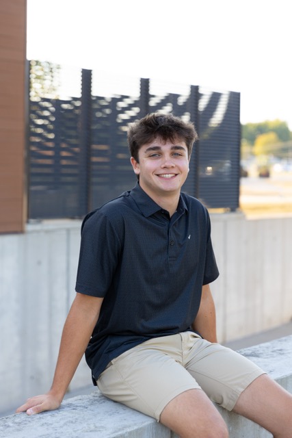 high school senior boy sitting on a wall at Summit Park Blue Ash Ohio