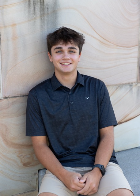 high school senior boy sitting on a bridge at Summit Park Blue Ash Ohio