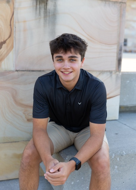 high school senior boy sitting on a bridge at Summit Park Blue Ash Ohio
