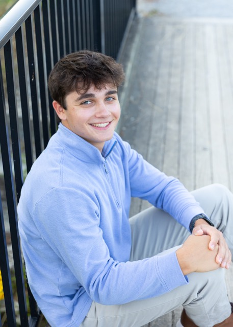high school senior boy sitting on a bridge at Summit Park Blue Ash Ohio