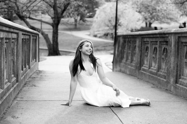 high school senior girl posing on bridge in white dress in Eden Park