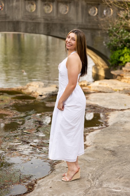 high school senior girl posing by the pond in white dress in Eden Park