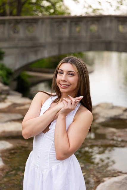 high school senior girl posing by the pond in white dress in Eden Park