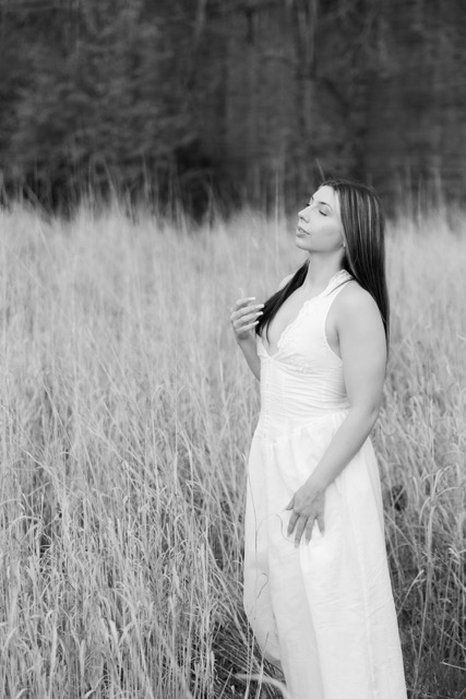 high school senior girl posing by tall grass in white dress in Eden Park
