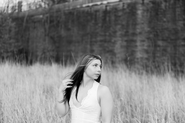 high school senior girl posing by wall in Eden Park
