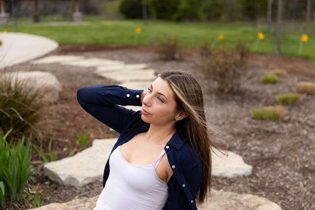 high school senior girl posing on a natural wood playscape
