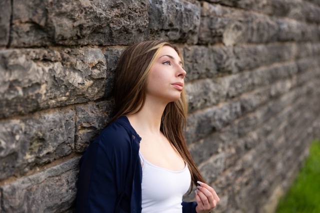 high school senior girl posing by wall in Eden Park