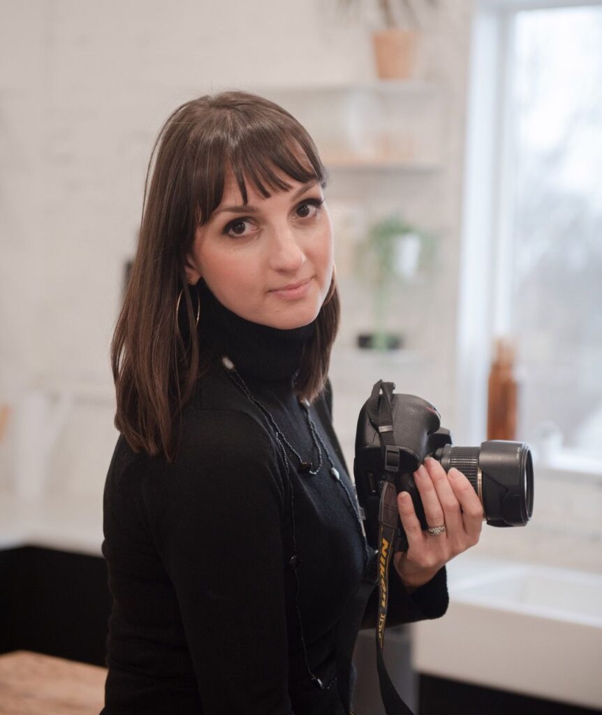 Agnes Kindberg holding a camera indoors.