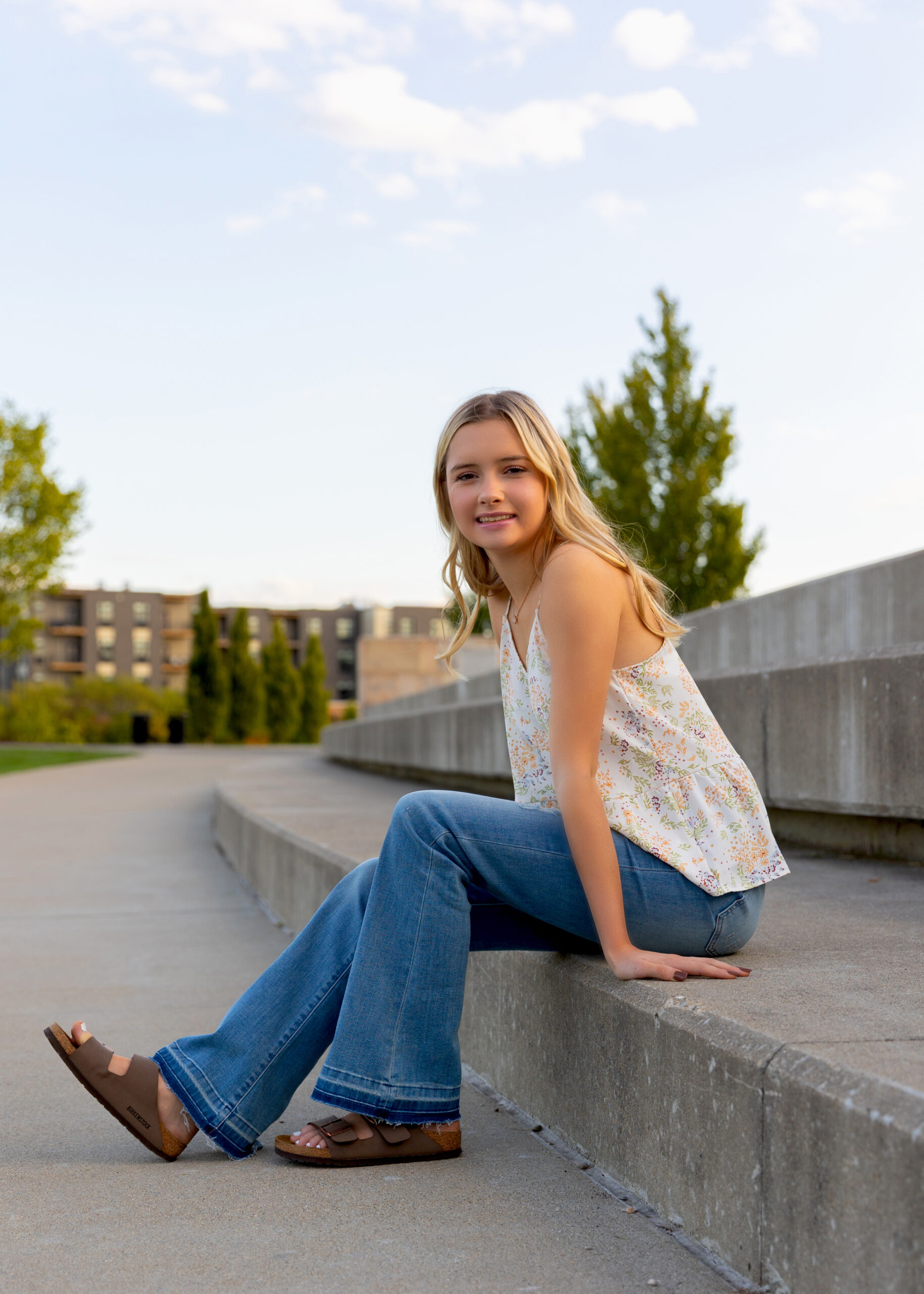 Young girl sitting on concrete steps outdoors.