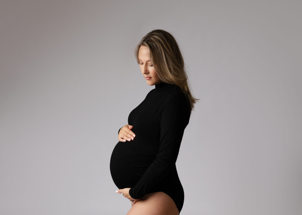 Pregnant woman in black dress side profile