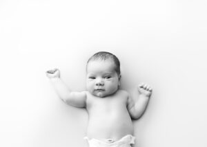 Newborn baby lying on back, black and white photo.