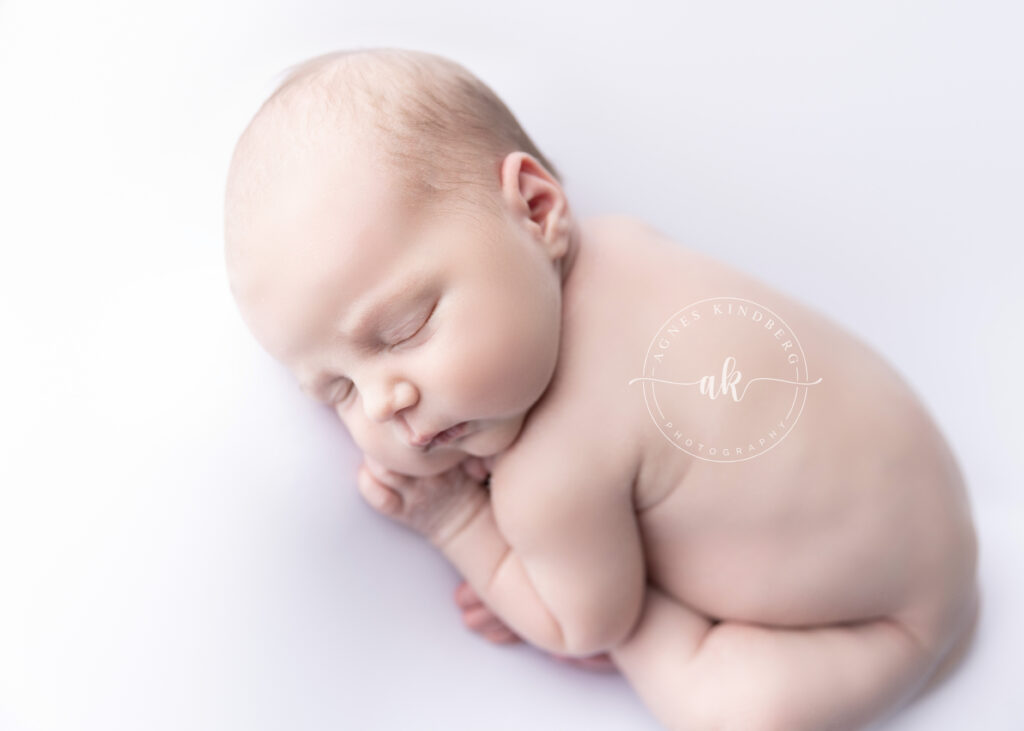 newborn baby in Taco Pose curled up 