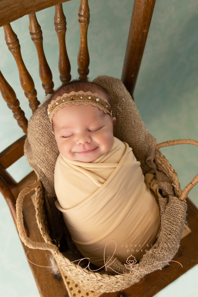 Newborn baby wrapped up as a Potato in a basket on a chair