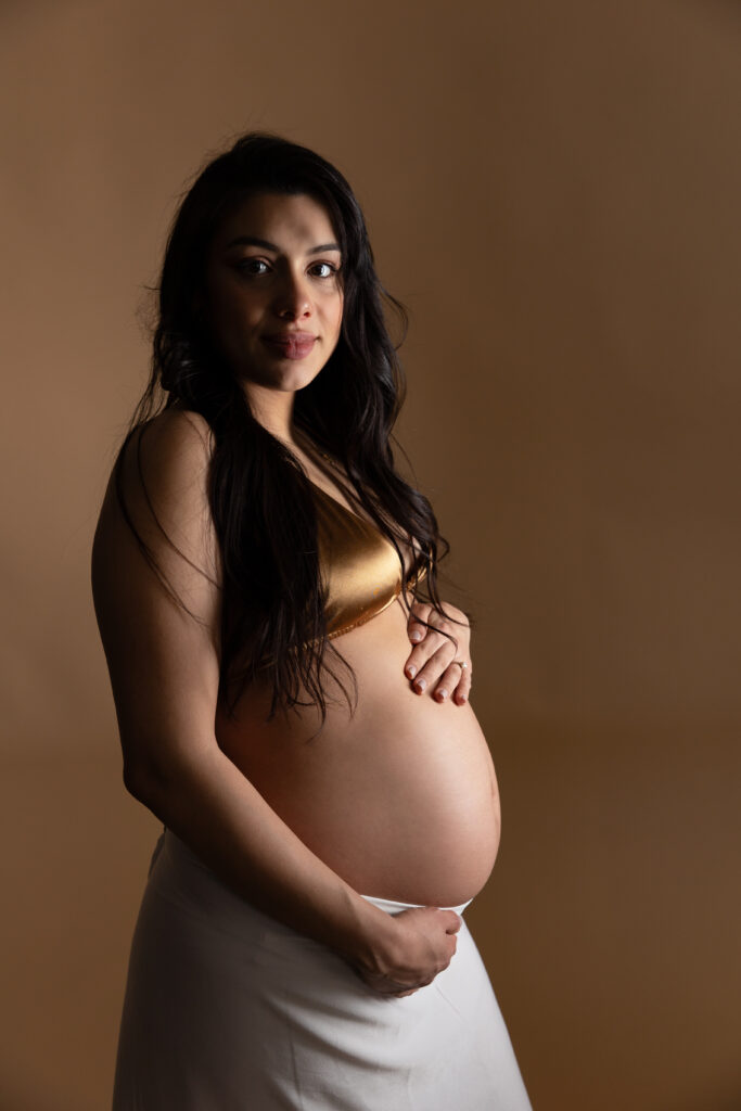 Pregnant woman in golden top and white skirt