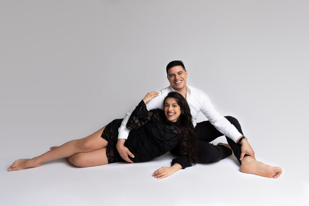 Smiling couple posing playfully in elegant attire