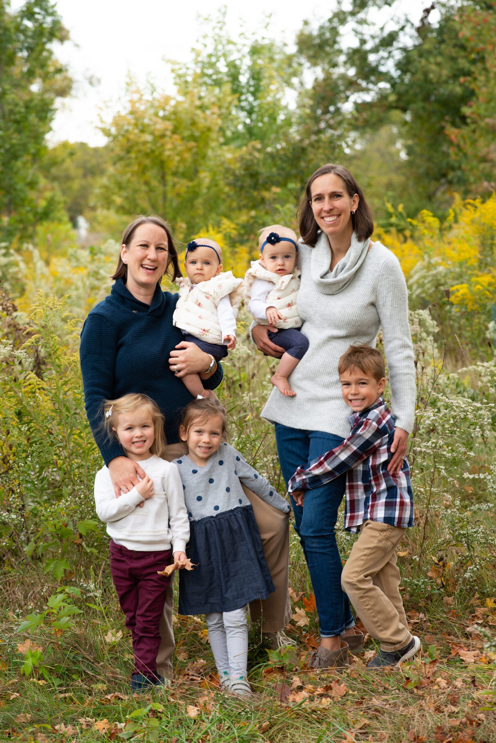 family of 7 all dressed up and posing in the Fall foliage