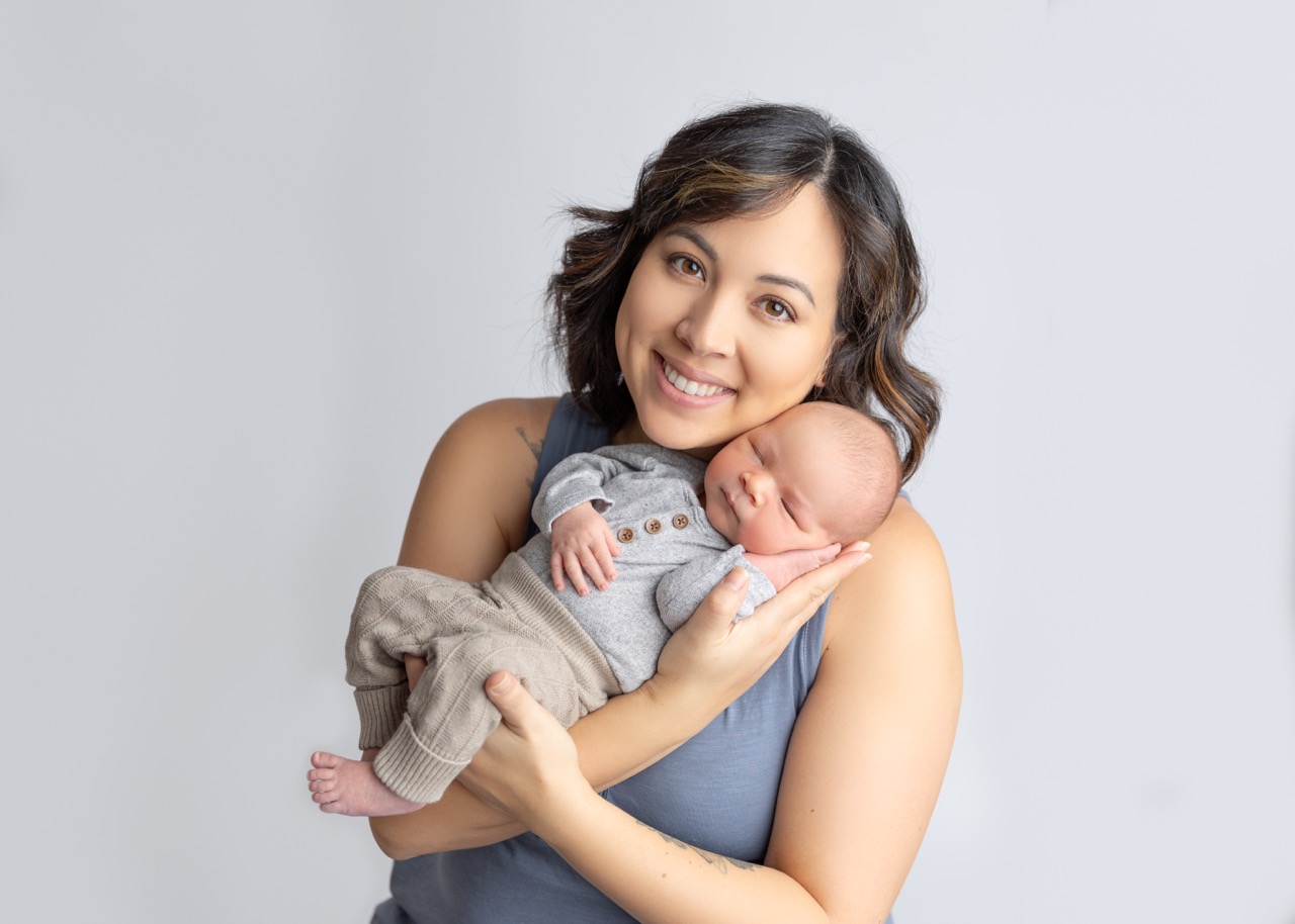 mom snuggling with baby in hands 