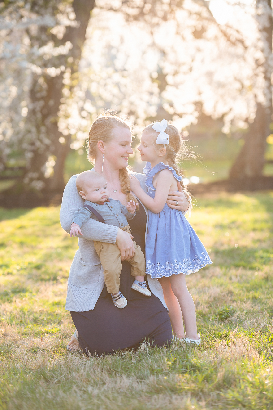 mom holding babies un the cherry blossoms in Ault Park Cincinnati