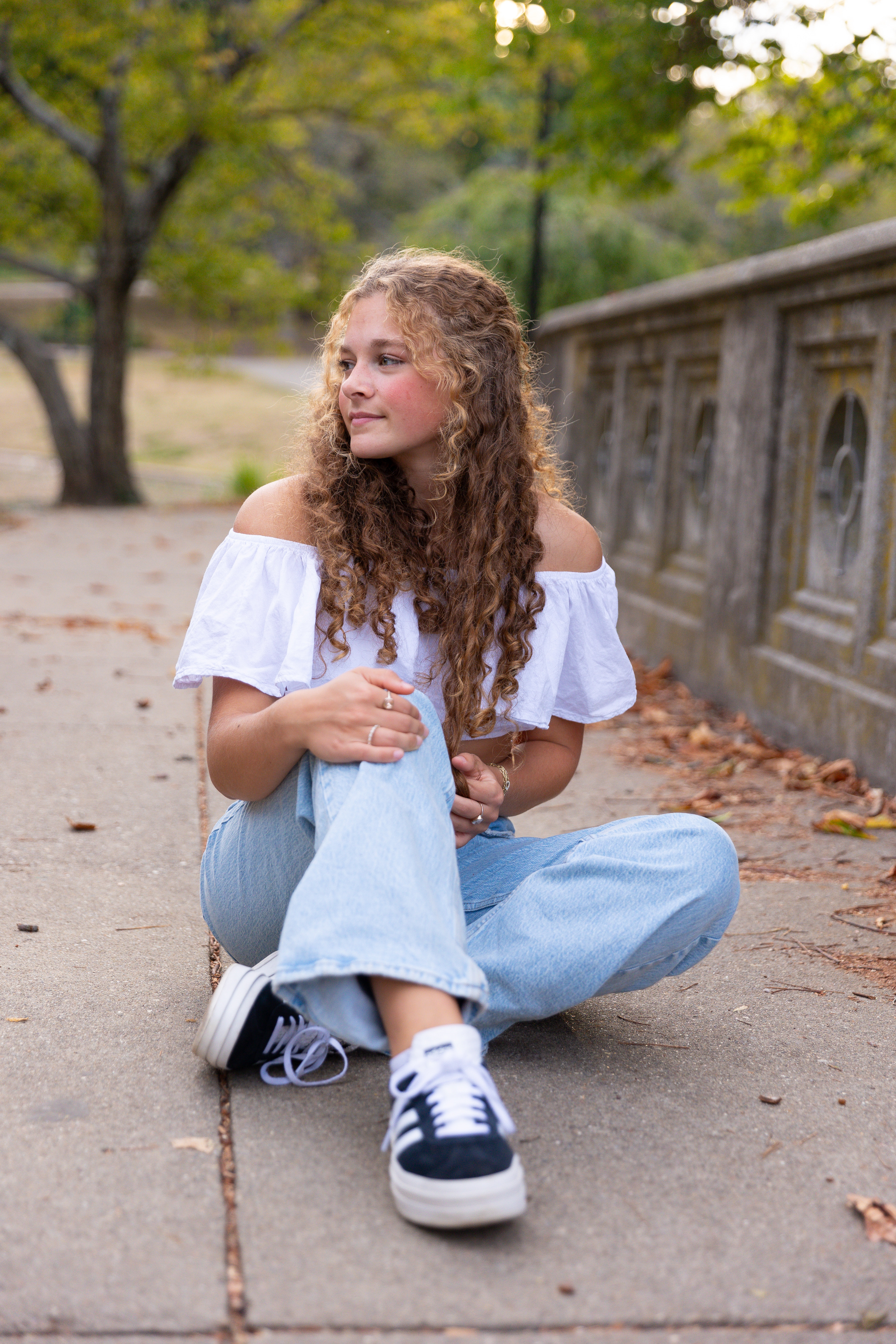 girl posing her knee bent on a bridge