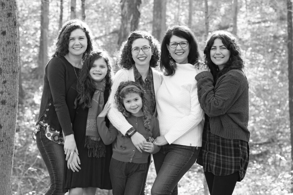 the girls of the family posing in front of trees in backyard
