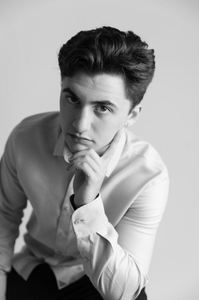 High School senior boy sitting on chair hand on chin