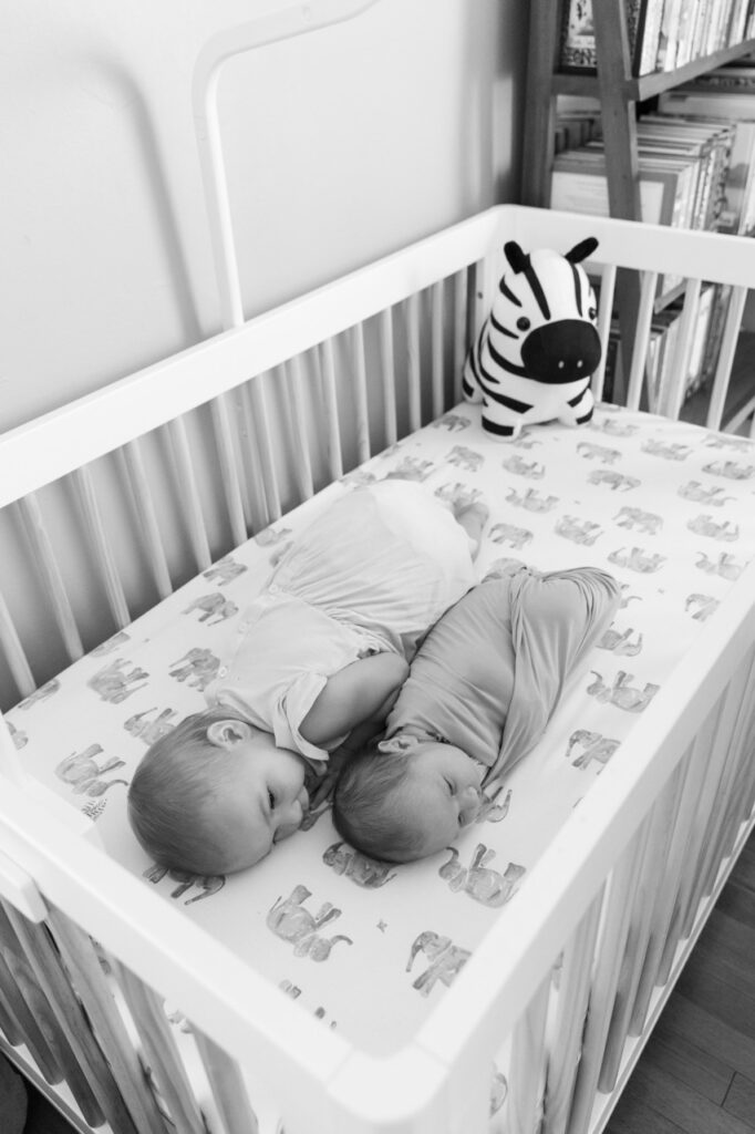 big sister snuggles baby in crib 