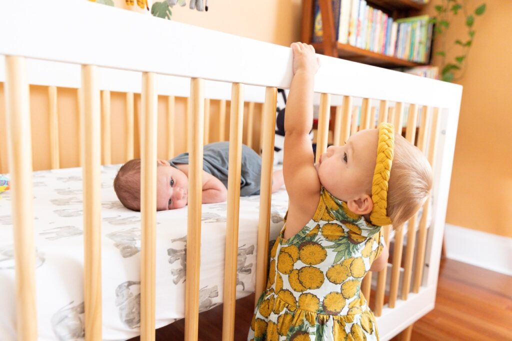 toddler climbing on side of crib