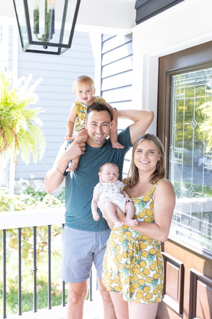 new family of 4 posing in front of front door in Oakley