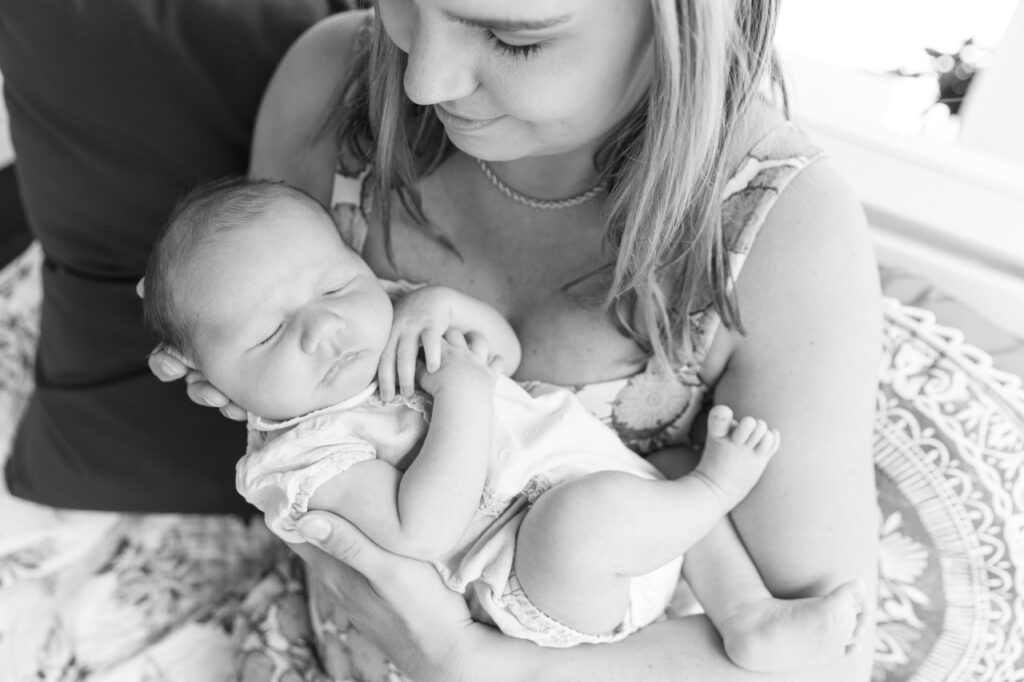 in home lifestyle newborn session, mom holding baby in Oakley 