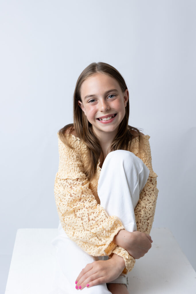 young girl sitting pose arm around knee