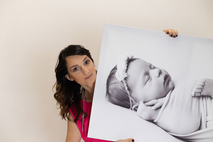 women holding a huge canvas image of baby