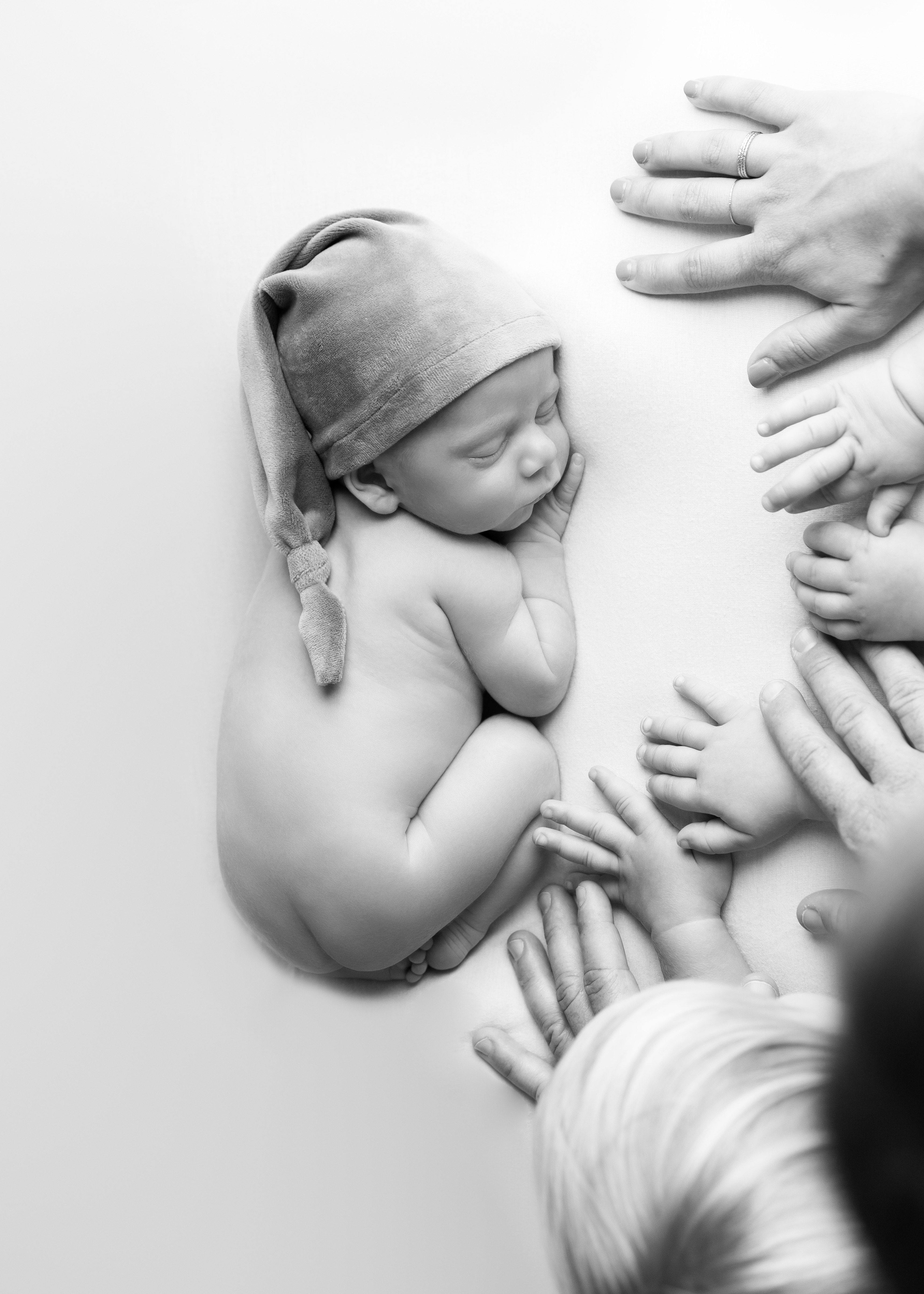 all hands on a newborn sleeping baby