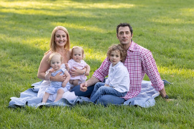 family sitting on a blanket at Ault Park during a photoshoot
