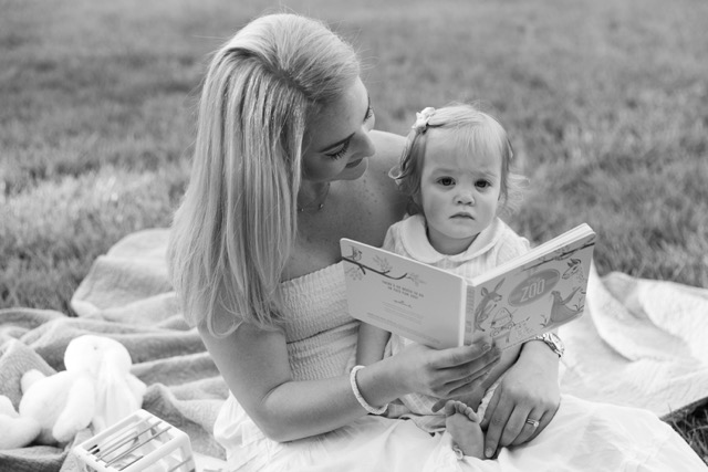mom reading to toddler girl on a blanket at Ault Park