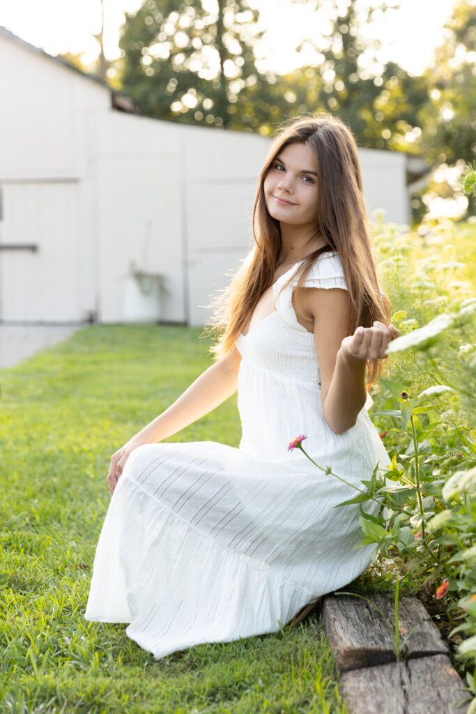 Senior girl in white dress at Marmalade Lily flower farm in Loveland Ohio.