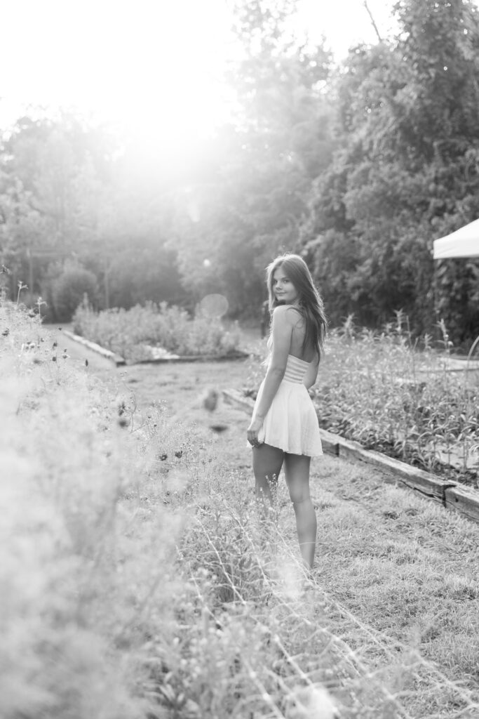 Senior girl in white dress at Marmalade Lily flower farm in Loveland Ohio