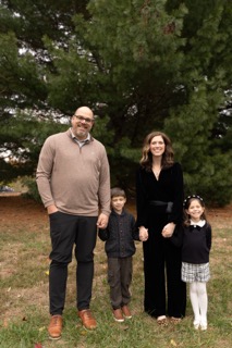 family posing for a mini photoshoot with beautiful evergreen trees at French Park
